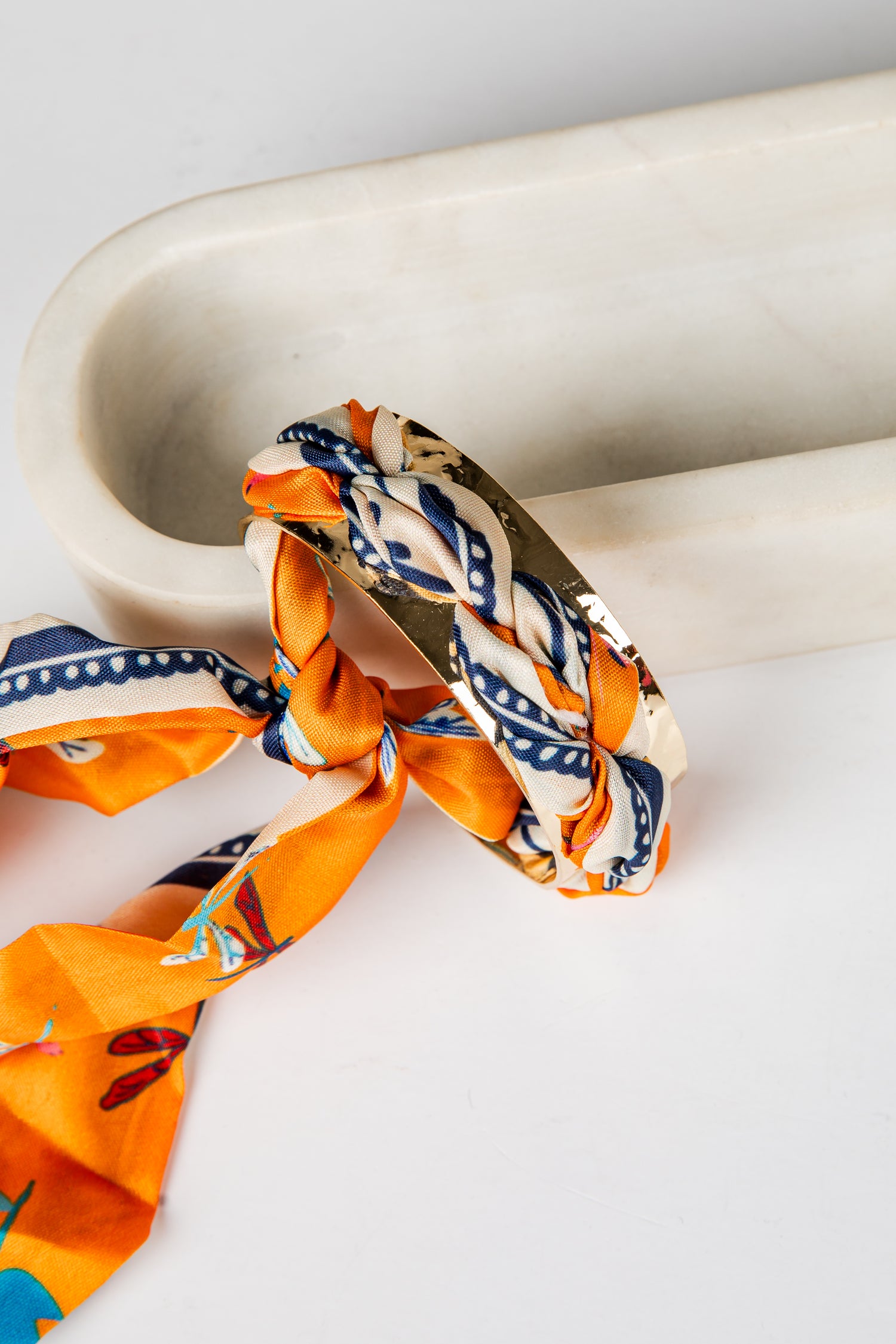Scarf with geometric pattern draped over a marble surface