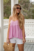 Woman wearing a pink top and white shorts on a porch