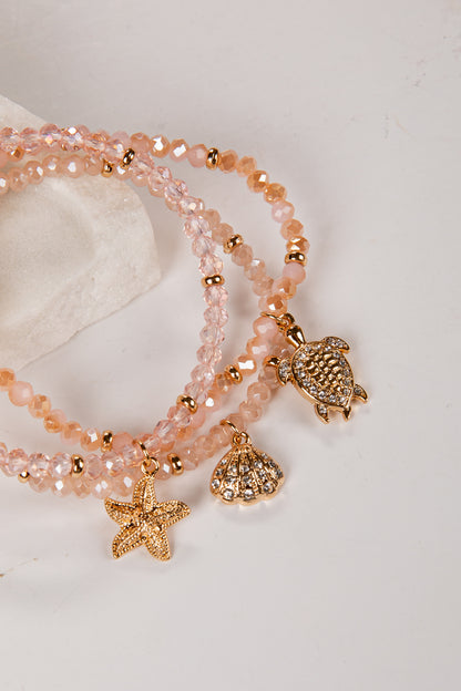 Set of beaded bracelets with turtle and starfish charms on a light background