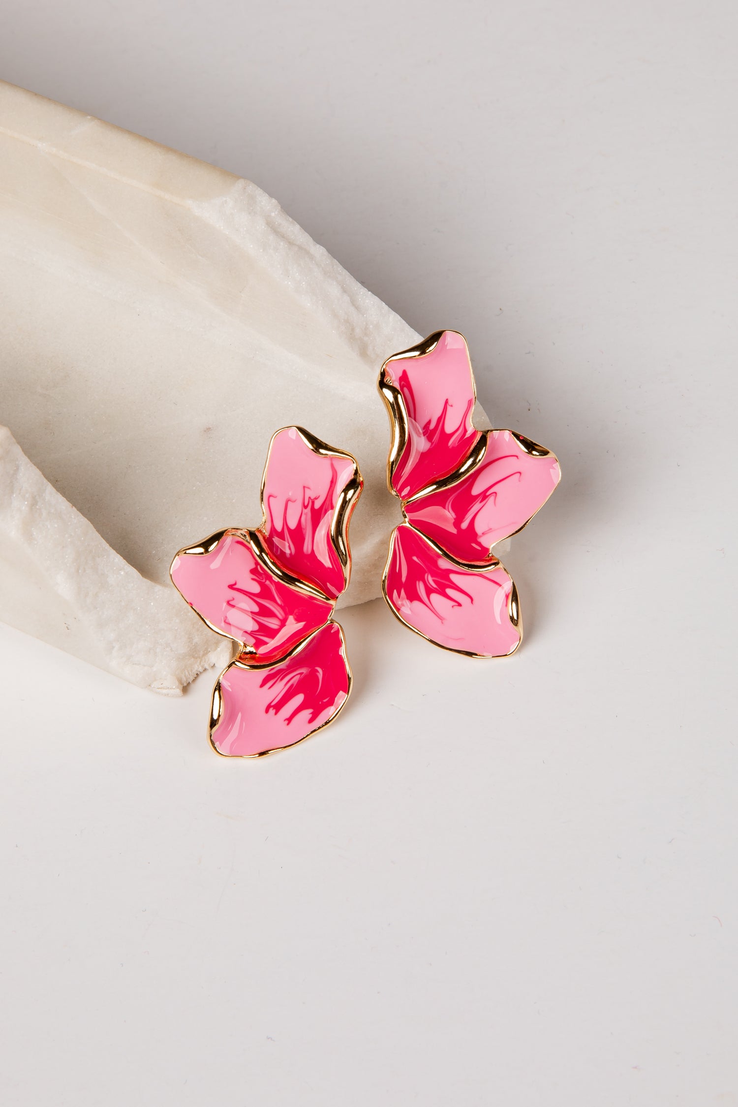 Pink butterfly-shaped earrings on a light background