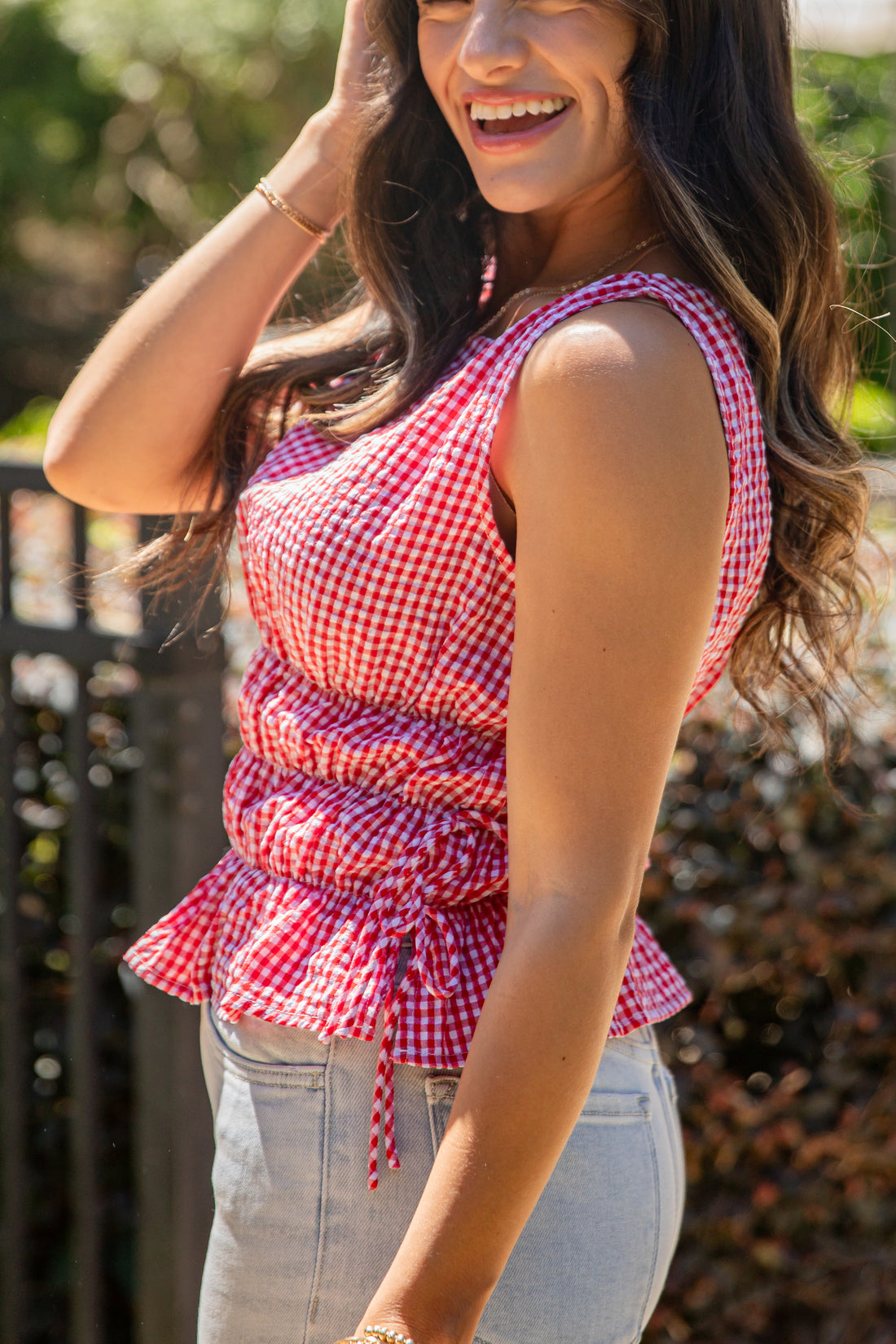 Woman wearing a red and white checkered top outdoors