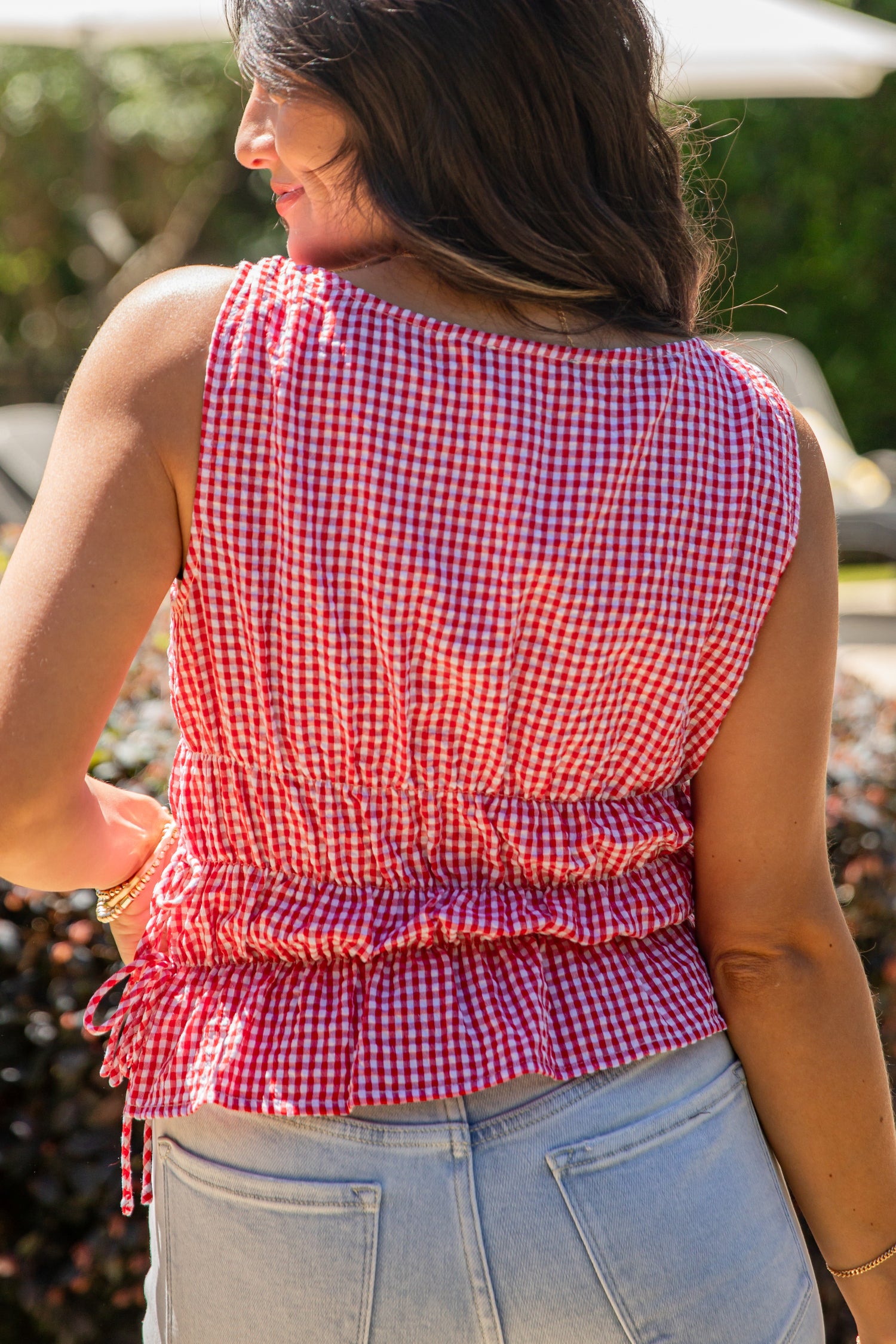 Woman wearing a red and white checkered top with a blurred background