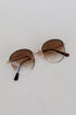 Round sunglasses with gold frame and brown lenses on a white background