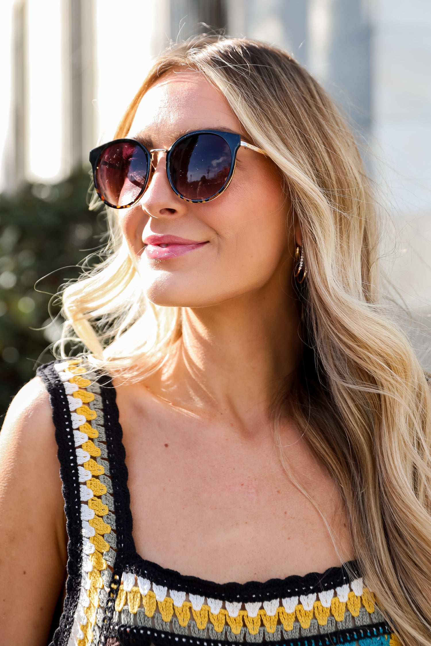 Sunglasses with dark lenses and tortoiseshell frame on a light gray background