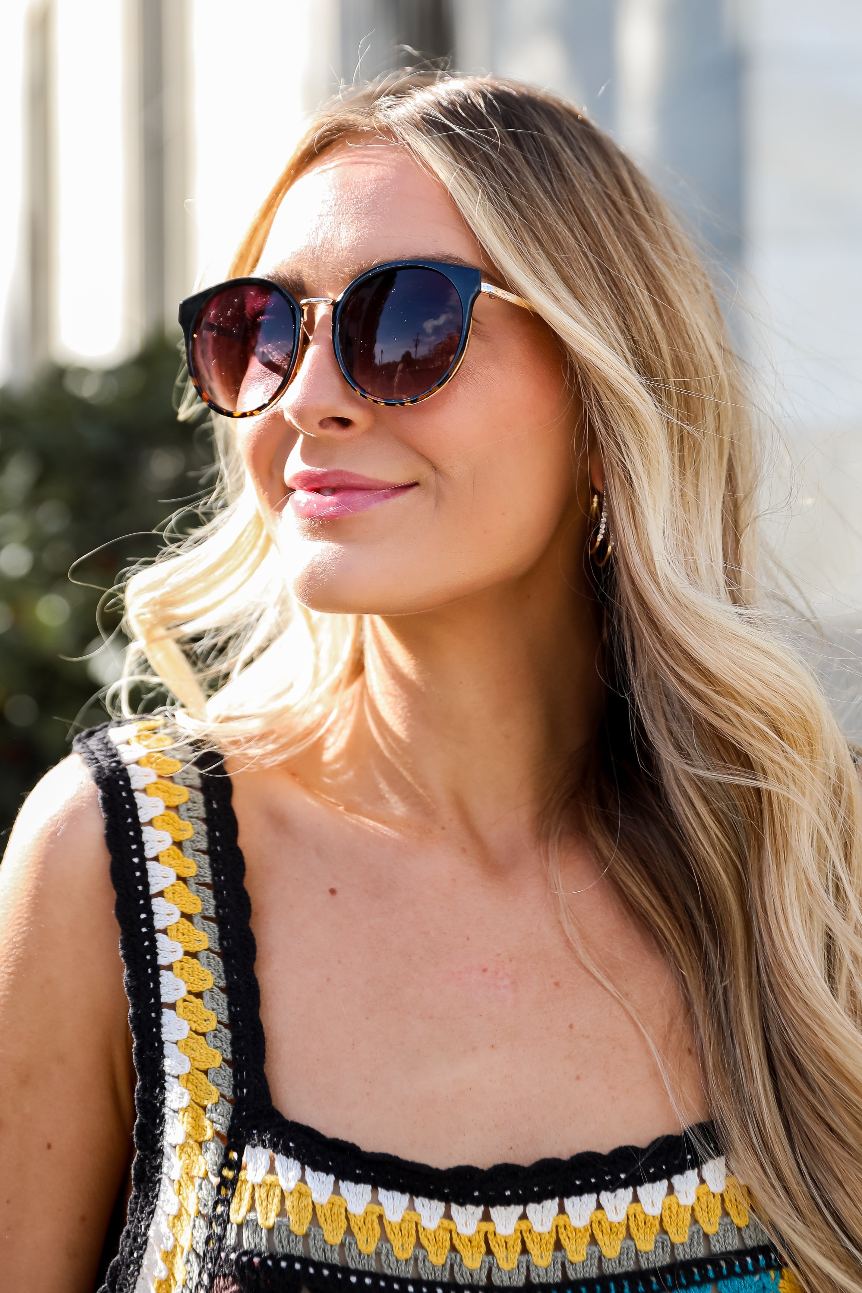 Sunglasses with dark lenses and tortoiseshell frame on a light gray background