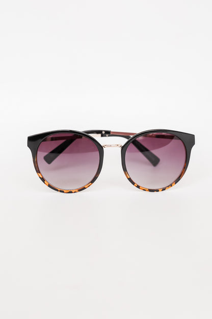 Sunglasses with tortoiseshell frame and gradient purple lenses on a white background