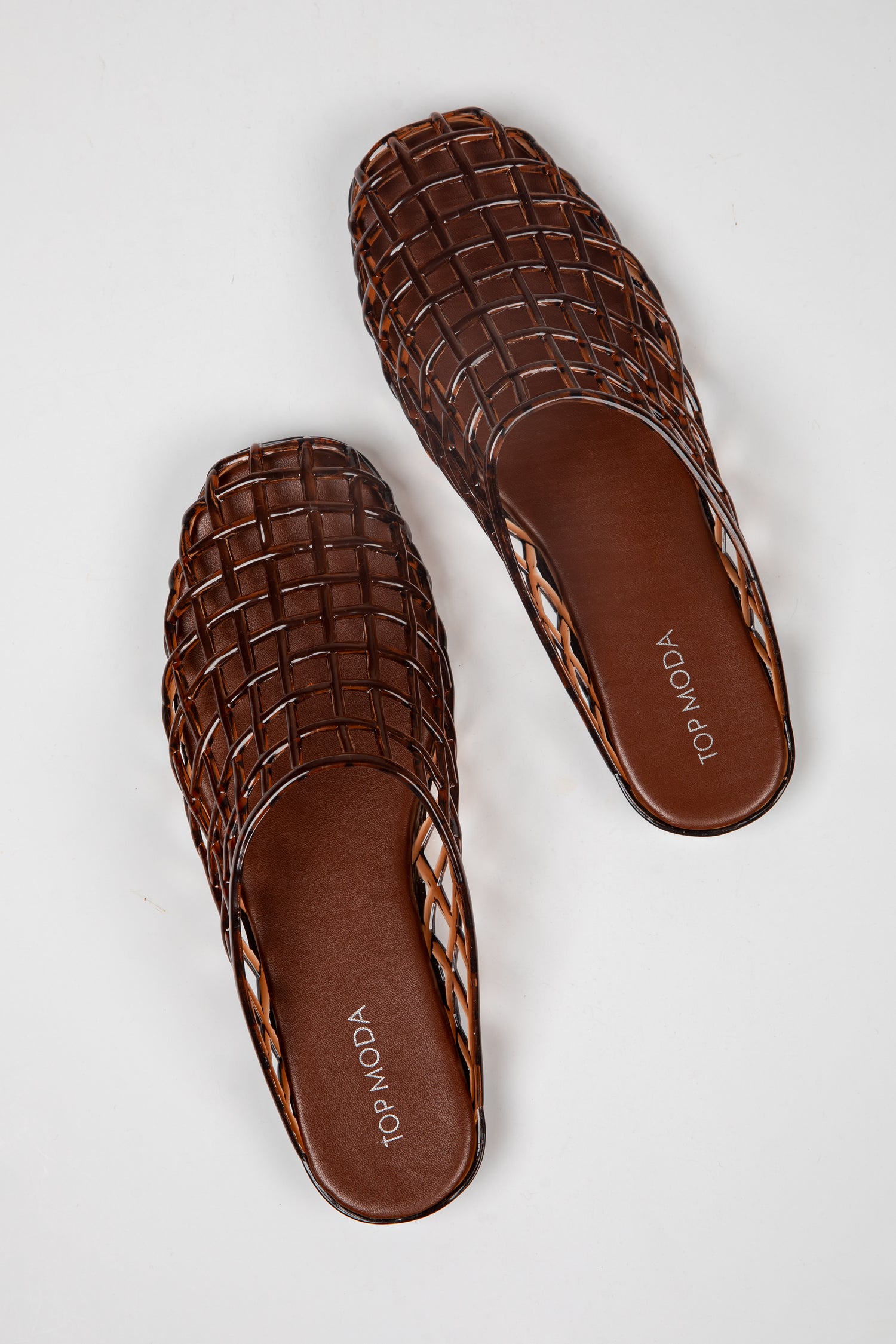 A pair of brown woven leather mule sandals with a square toe, displayed on a light gray background. The brand name &