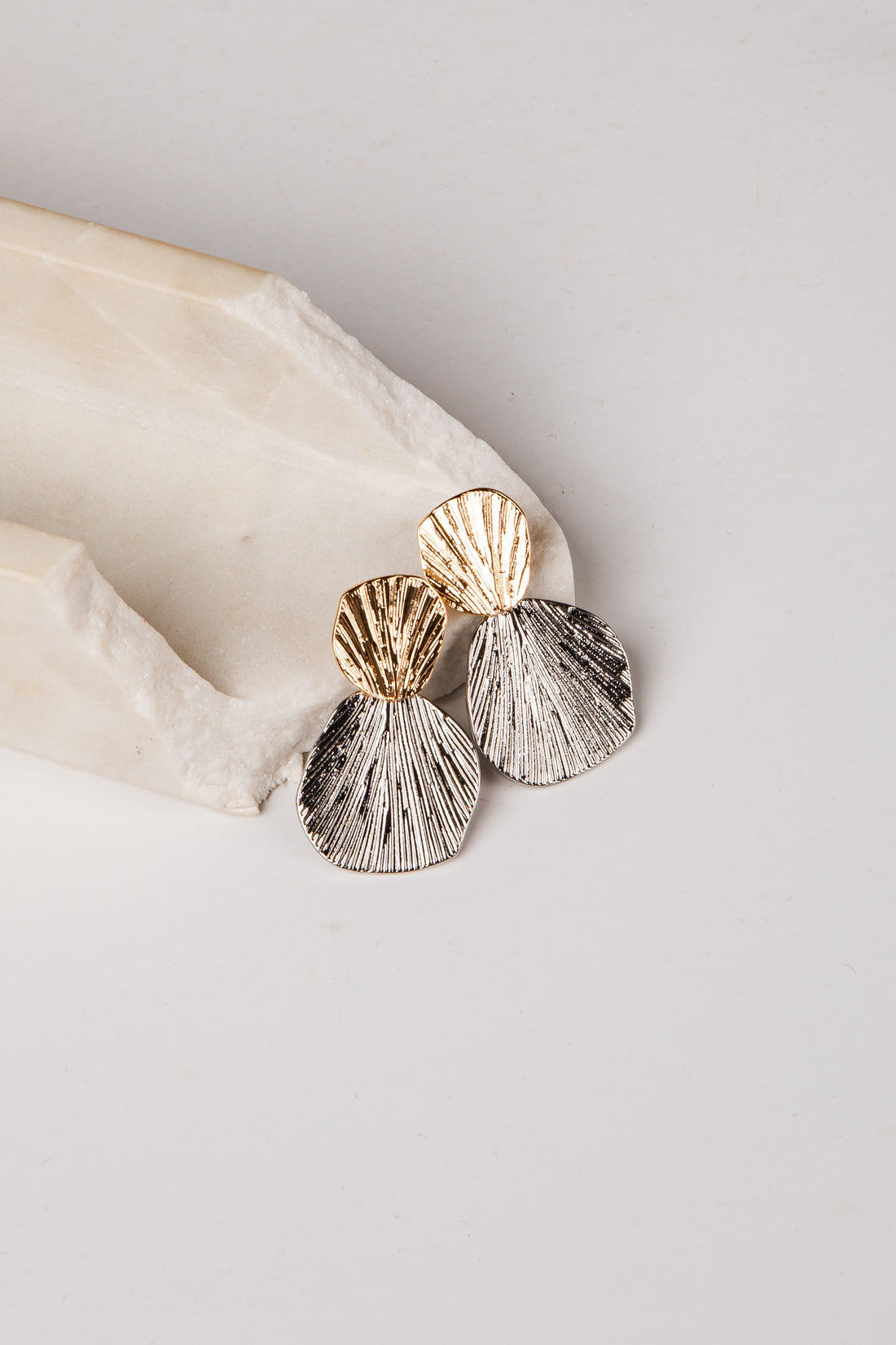 Shell-shaped earrings on a light background
