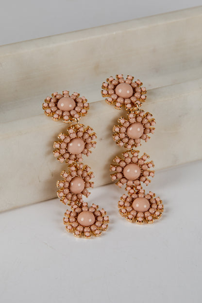 Pair of pink beaded earrings on a marble surface