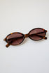 Sunglasses with tortoiseshell frame and brown lenses on a white background