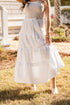 Woman wearing a white dress standing outdoors on grass