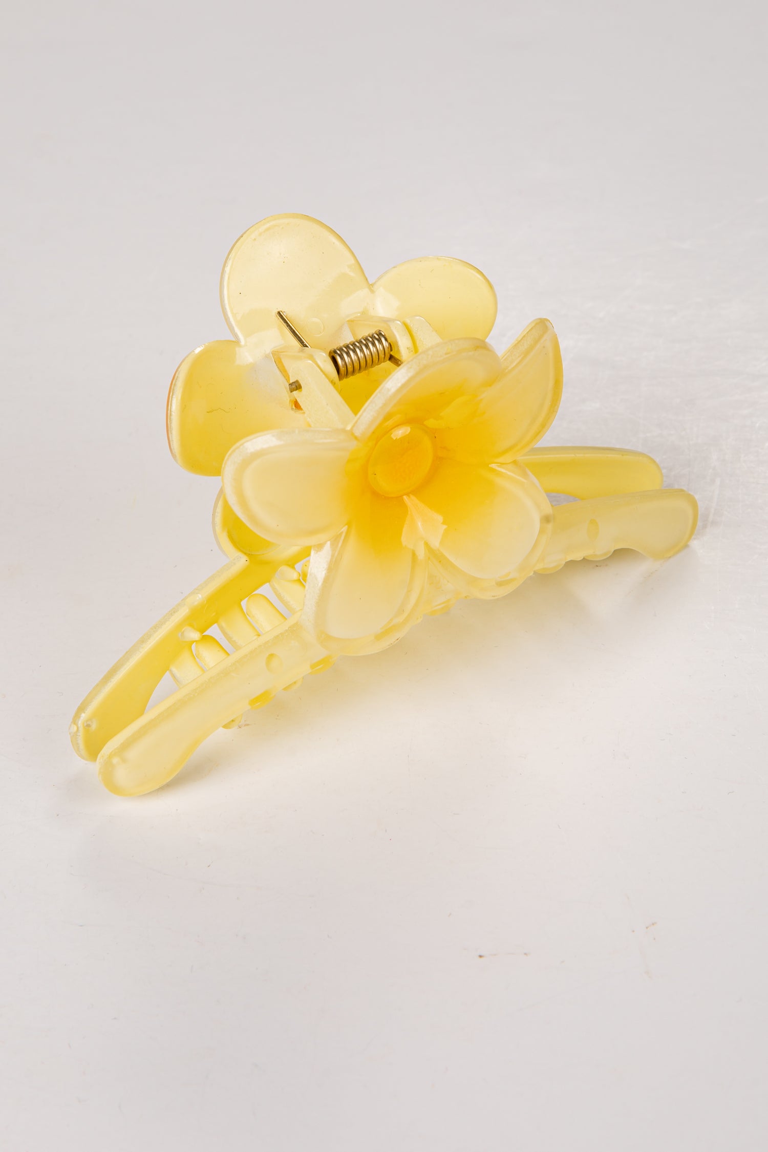 Yellow floral hair clip on a white background