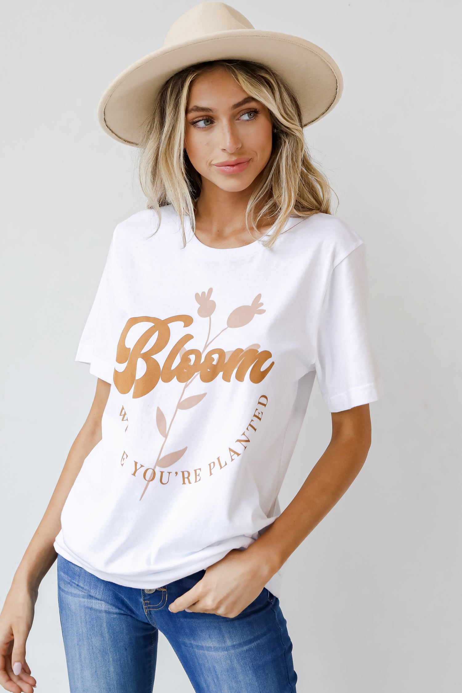 This comfy tee is designed with a soft and stretchy knit. It features a crew neckline, short sleeves, a relaxed fit, and the words "Bloom Where You&