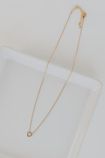 Gold Heart Charm Necklace flat lay