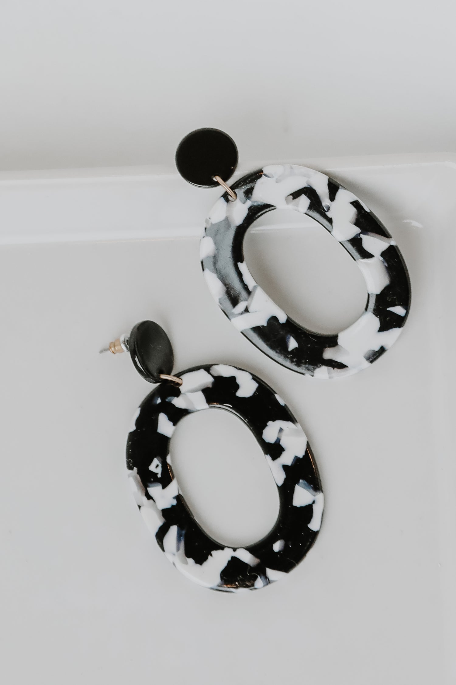 Acrylic Statement Earrings in black flat lay